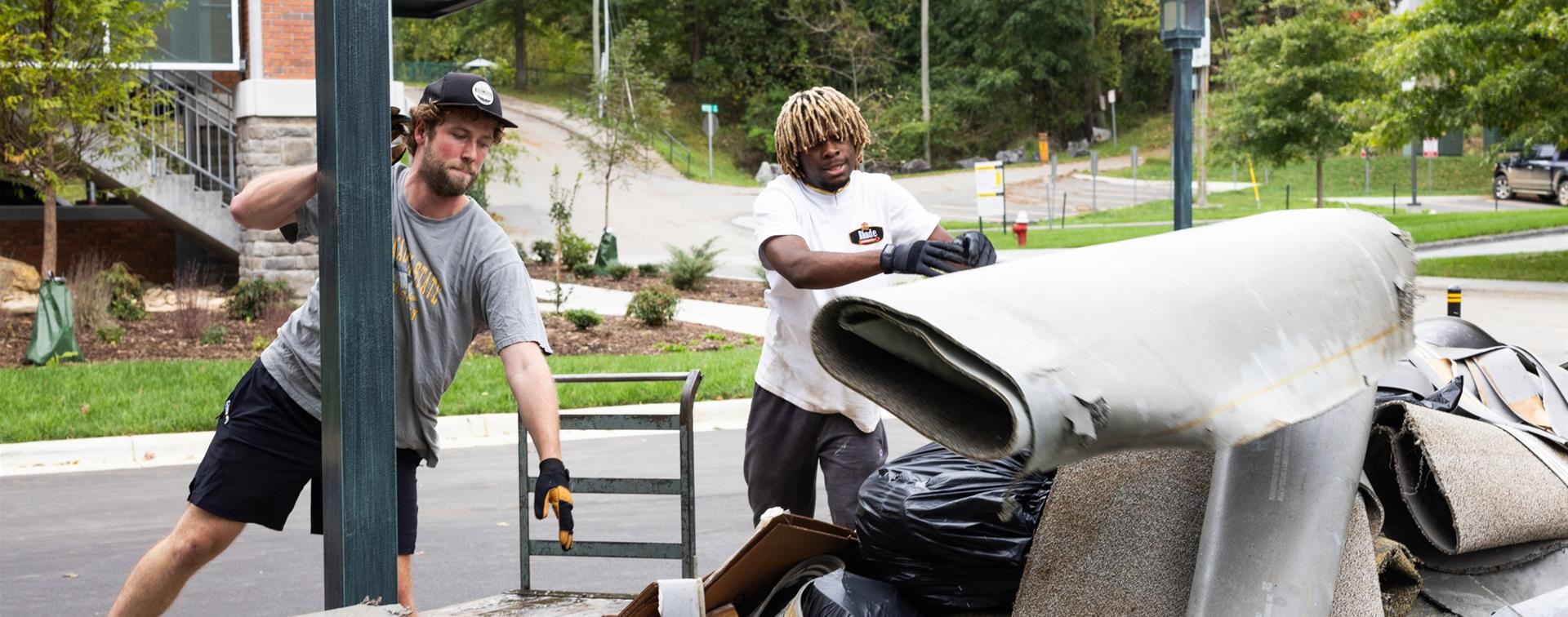 Two men remove damaged carpeting from building on Appalachian State campus in the wake of Hurricane Helene